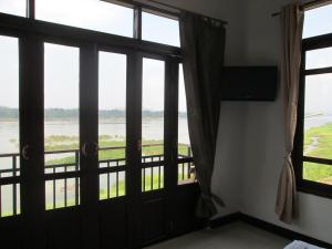 Cette chambre dispose d'une porte et de fenêtres avec vue. dans l'établissement Norn Nab Dao Rimkhong, à Chiang Khan