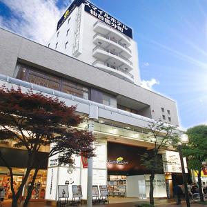 un grande edificio con tavoli e sedie di fronte di Smile Hotel Sendai-Kokubuncho a Sendai