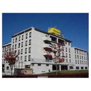 郡山市にあるスマイルホテル郡山の白い建物の上に黄色い看板