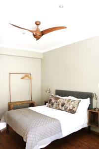 a bedroom with a bed with a ceiling fan at Avo&Oak Guesthouse in George