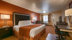 ein Hotelzimmer mit einem großen Bett und einem Schreibtisch in der Unterkunft SureStay Hotel by Best Western Zapata in Zapata