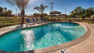 a swimming pool with lounge chairs and a swimming pool at SureStay Hotel by Best Western Zapata in Zapata