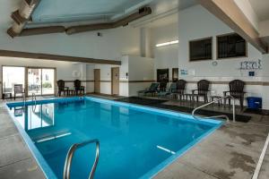 a large swimming pool with chairs and a table at SureStay Plus Hotel by Best Western Post Falls in Post Falls