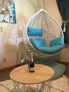 a swing chair with a bottle of wine and two glasses at Breakfast at Tiffanys in Queenstown