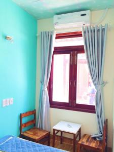 a bedroom with a bed and a window with curtains at Bot Bien Homestay in Mui Ne