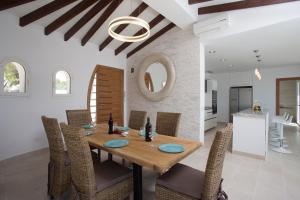 a dining room with a wooden table and chairs at Blue Dream Villa in Jávea
