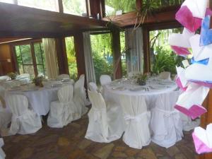 a room with white tables and white chairs and windows at Casaquinta City Bell in City Bell +39 photos