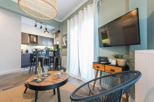 a living room with a table and chairs and a television at "SunBow Olive"- Boutique Apartment in Dowtown Athens in Athens