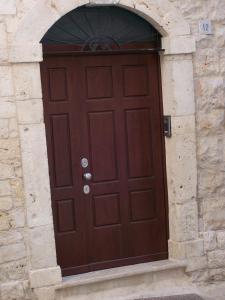 a brown wooden door in a stone building at BeMyGuest Rutigliano in Rutigliano