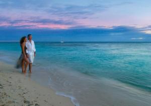 a man and a woman standing on the beach at Green Island Resort in Green Island