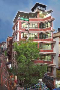 a tall red brick building with a tree in front of it at Sakura Boutique Hotel in Kathmandu