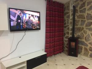 TV de pantalla plana en la pared de la sala de estar. en Apartamento Arco del Cristo, en Cáceres