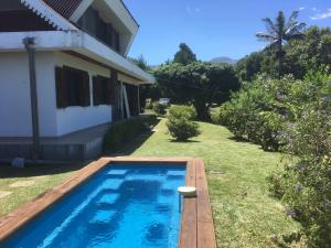 a swimming pool in a yard next to a house at Caloupilé in Le Tampon