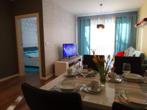 a living room with a table and a dining room at Apartament Dwie Sosny in Ustronie Morskie