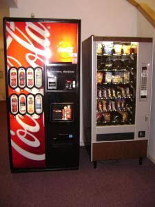 una máquina expendedora de coca cola junto a una máquina de refrescos en Edgewick Inn, en North Bend