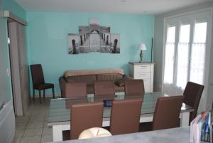 een woonkamer met een tafel en stoelen en een bank bij gîte la belle vue in Saint-Martin-en-Campagne