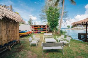 a group of chairs and tables next to the water at Airai Ocean View Lodge in Koror