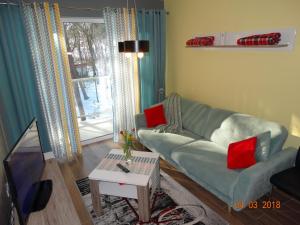 a living room with a couch and a tv at Apartament Dwie Sosny in Ustronie Morskie