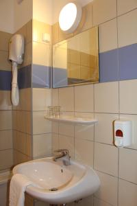 y baño con lavabo y espejo. en Nereus Park Hotel, en Balatonalmádi