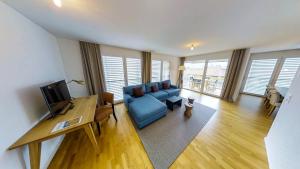 a living room with a blue couch and a table at Apartment Spedition in Thun