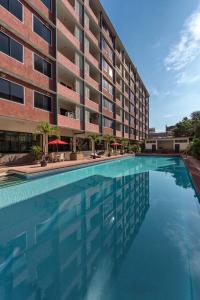 a swimming pool in front of a building at Capital Mansion - SHA Certified in Bangkok