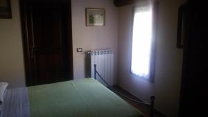 a bedroom with a green bed and a window at Locanda Dei Boi in Ventimiglia