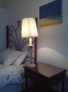 una lámpara en una mesa junto a una cama en Casa Rural San Miguel Zufre, en Zufre
