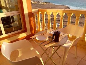 uma mesa e cadeiras numa varanda com vista para o oceano em Playa Paraiso em Costa Calma