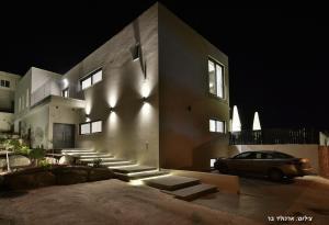 a car parked in front of a building at night at Villa J in Migdal