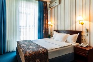 - une chambre avec un grand lit et une fenêtre dans l'établissement Tengri Hotel, à Astana