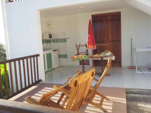 a balcony with two chairs and a table with an umbrella at Gîtes Alamanda in Bouillante