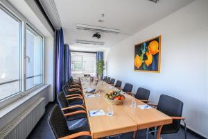 une salle de conférence avec une grande table et des chaises dans l'établissement Hotel Plaza Hannover, à Hanovre