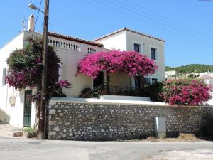 a white house with pink flowers on a wall at Victoria Studios in Spetses