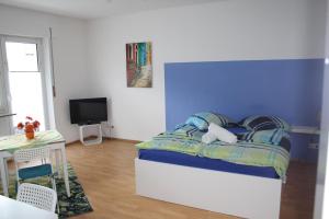 una camera da letto con un letto con una parete blu di Vida Real Estate Nürnberg a Norimberga