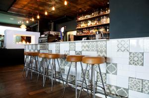 a row of stools at a bar in a restaurant at La Splendida Hotel by NEWMARK in Cape Town