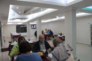 a group of people sitting at tables in a restaurant at Sultan Pansion Bird Paradise in Ovaciftlik