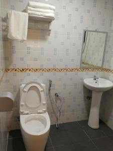 
a bathroom with a toilet a sink and a bath tub at Hotel Zuhra in Sibu
