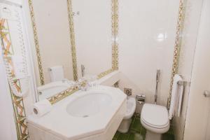 La salle de bains est pourvue d'un lavabo blanc et de toilettes. dans l'établissement Albergaria Senhora do Monte, à Lisbonne