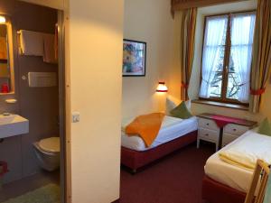 a small room with two beds and a toilet at Hotel Waltraud Garni in Kochel