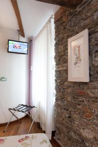 a bedroom with a stone wall and a window at L'Ancora in Riomaggiore