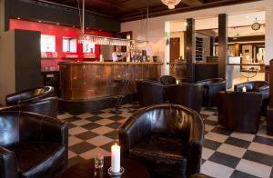 un restaurante con sillas de cuero y un bar en Hotel Vinhuset, en Naestved