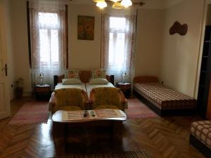 een woonkamer met 2 bedden en een bank bij Homoky Pincészet és Vendégház in Tállya