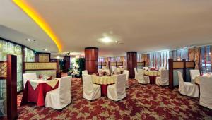 a banquet room with white tables and white chairs at Super House International in Beijing