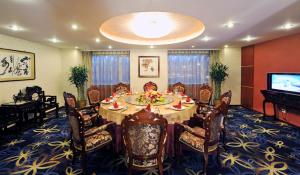 a dining room with a table and chairs and a television at Super House International in Beijing