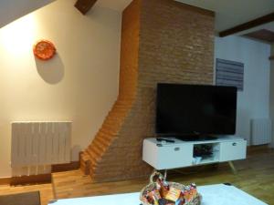 een woonkamer met een televisie en een trap bij Chez Christian in Auxonne