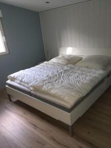 Exklusives Ferienhaus keine Monteure في Lichtenau: سرير أبيض كبير في غرفة نوم مع أرضية خشبية
