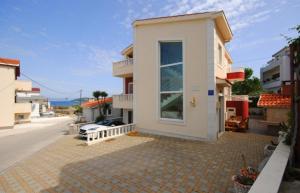 a small white house with a door on a street at Villa Guliver in Slatine