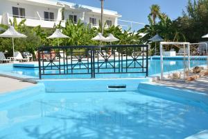 a blue swimming pool with a volley ball court at Costa Angela Seaside Resort in Kos Town