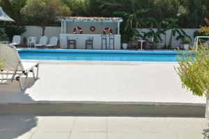 a swimming pool with a table and chairs next to it at Costa Angela Seaside Resort in Kos Town