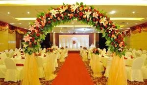a banquet hall with white chairs and a large floral arch at Super House International in Beijing
